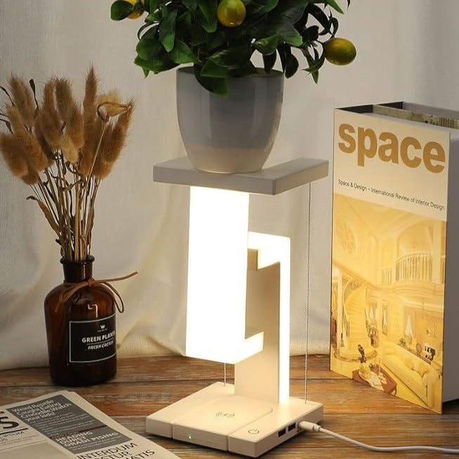 Small table lamp on a wooden surface with a plant and magazine in the background