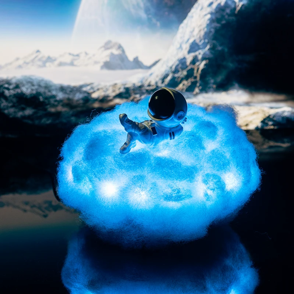 Small model of an astronaut on a cloud with a snowy landscape and planet in the background