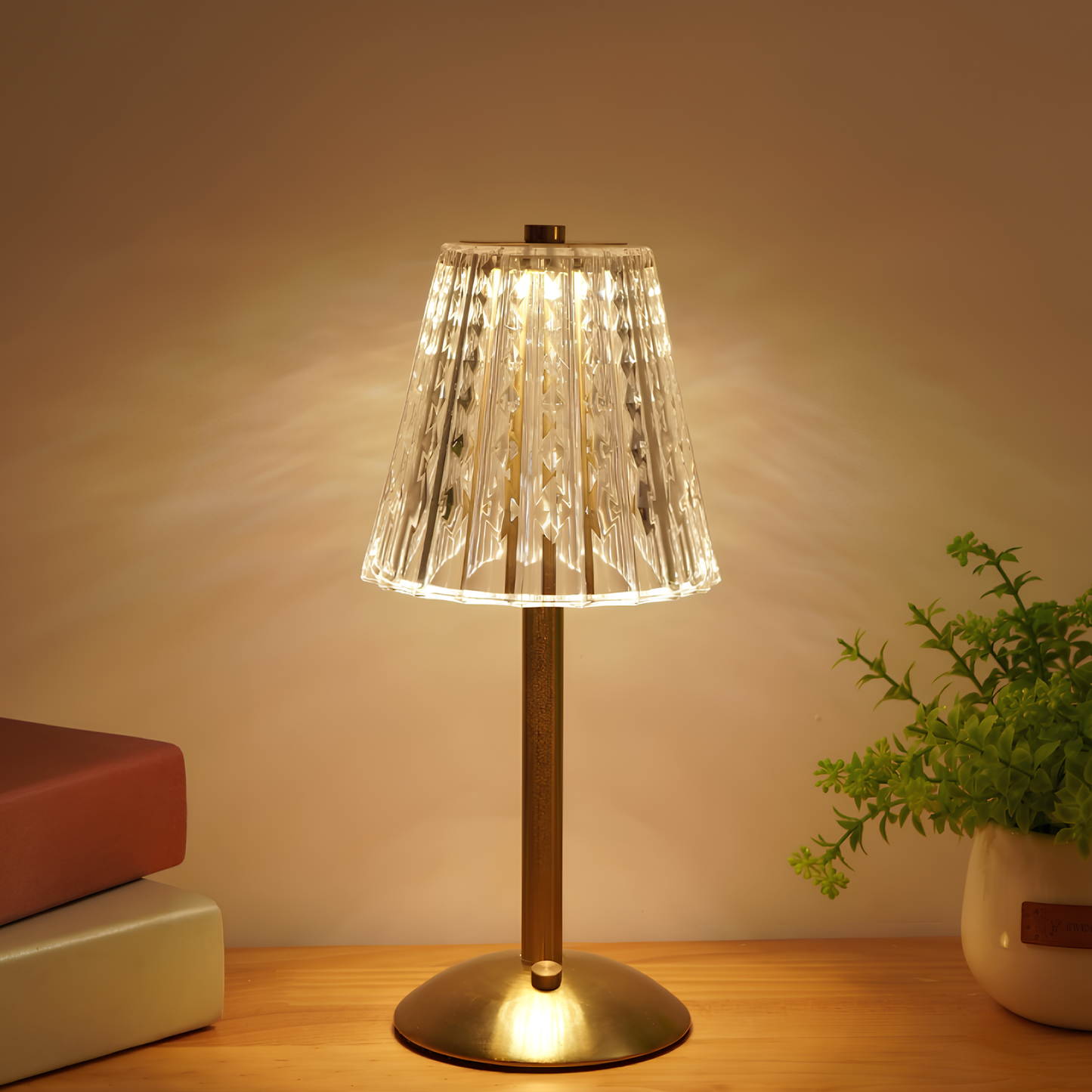 Table lamp with a clear glass shade on a wooden surface, emitting a warm glow.