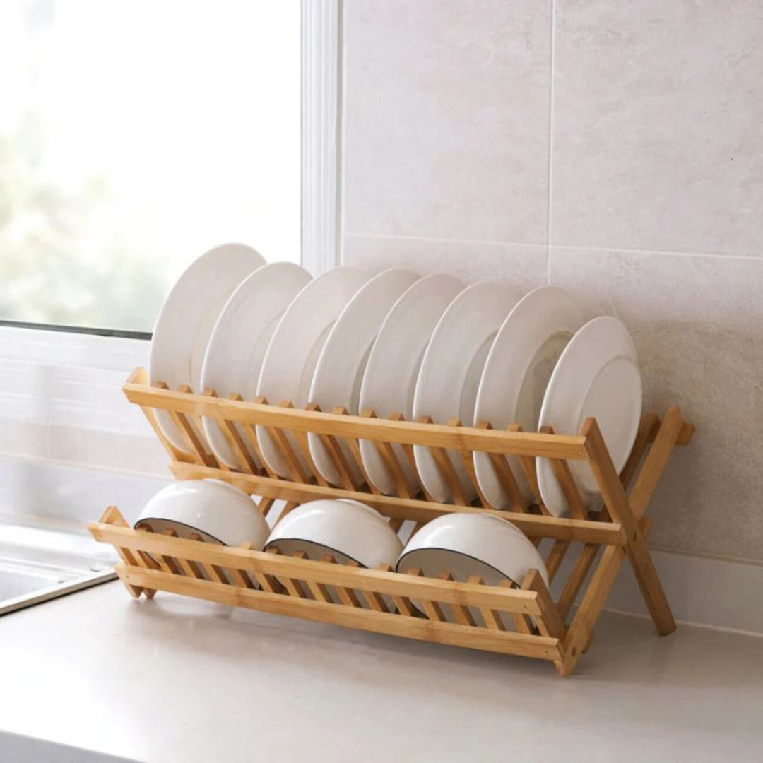 Wooden dish rack with white plates on a kitchen counter.