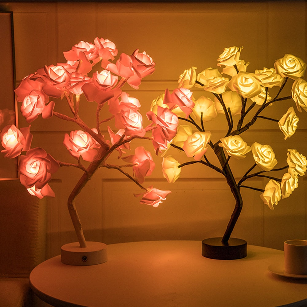 Two LED rose tree lamps on a table with a warm glow.