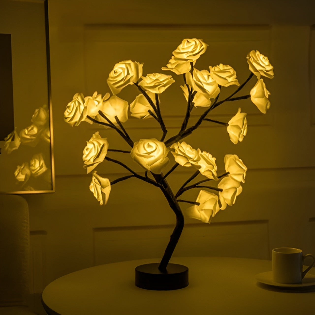 Decorative LED lamp shaped like a rose bush on a table with a cup in the background.