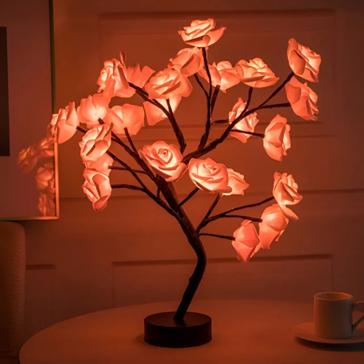 Decorative lamp with pink rose-shaped lights on a table.
