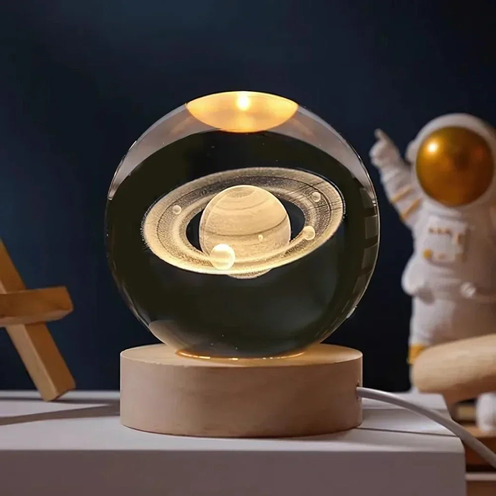 Decorative lamp with Saturn design on a wooden base, with an astronaut figure in the background.