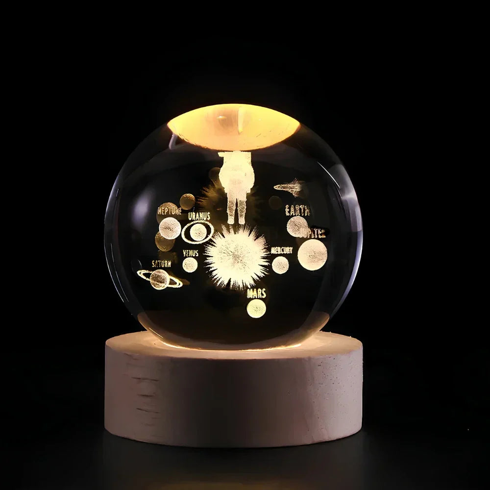 Decorative glass sphere with solar system design on a wooden base against a black background
