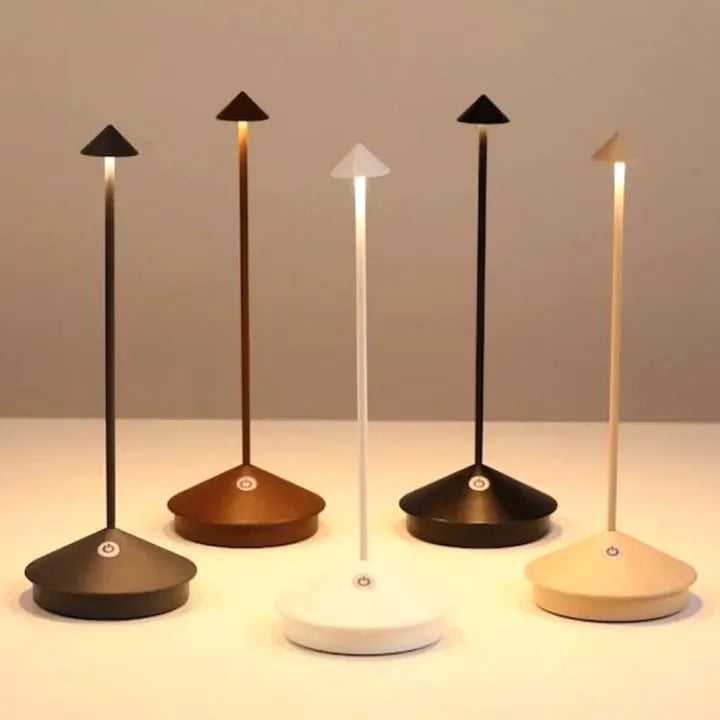 Set of five modern desk lamps with different base colors on a neutral background