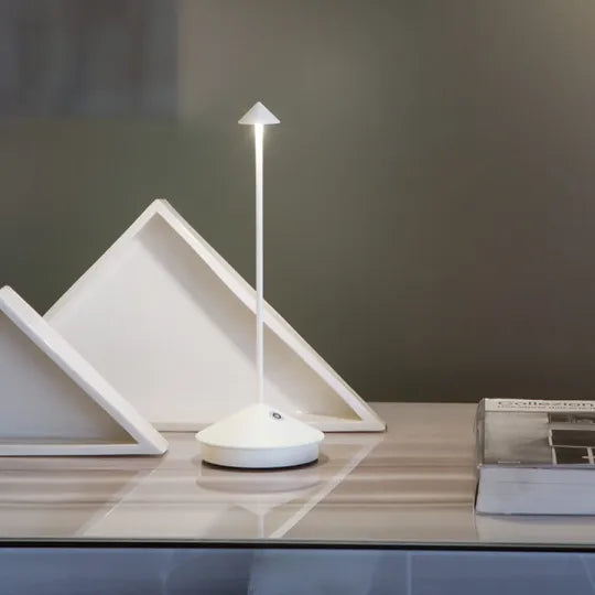 Modern white lamp on a wooden surface with a minimalistic design.
