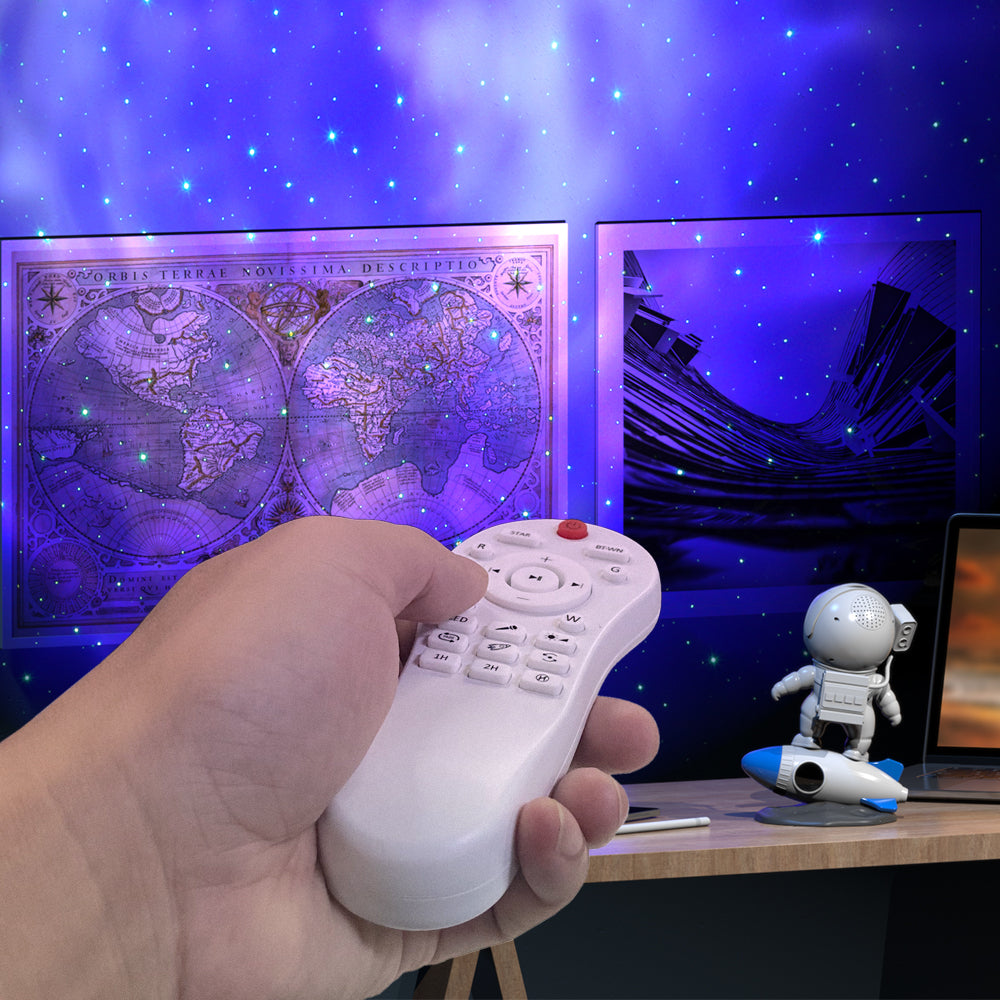 Hand holding a remote control with a starry night sky and world map projection in the background.