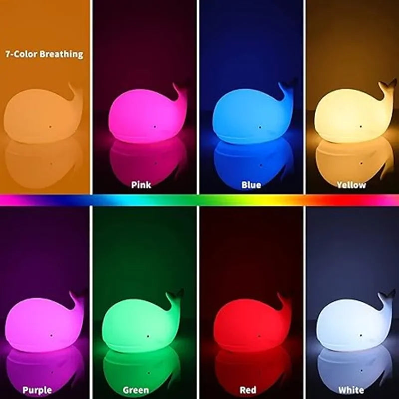 Whale-shaped night light displaying 7 different colors on a reflective surface.