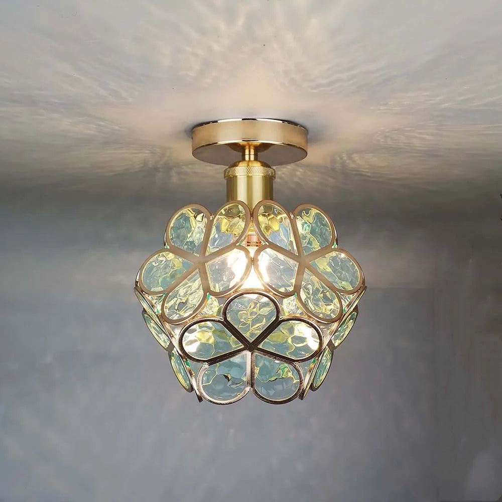 Ceiling light fixture with decorative glass shade on a neutral background