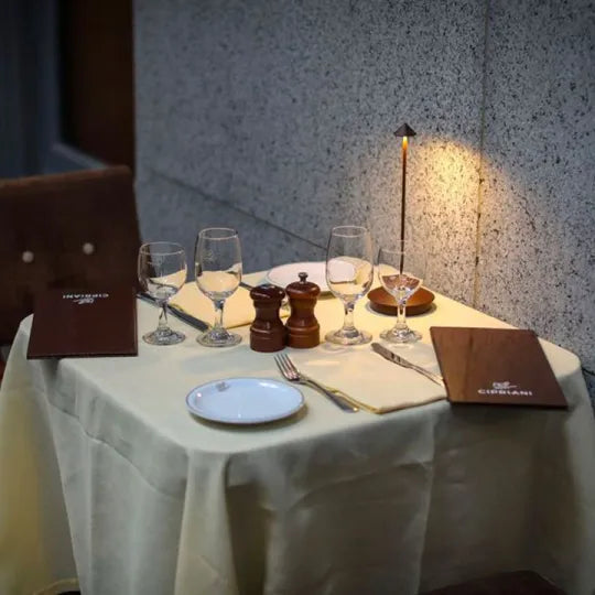 Dining table set with wine glasses, plates, and cutlery in a restaurant setting.