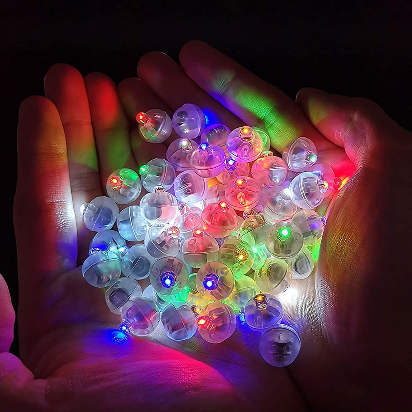 Colorful LED lights in a person's hands with a dark background