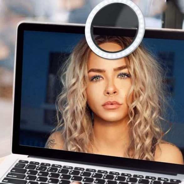 Laptop screen displaying a woman's face with a ring light attachment.
