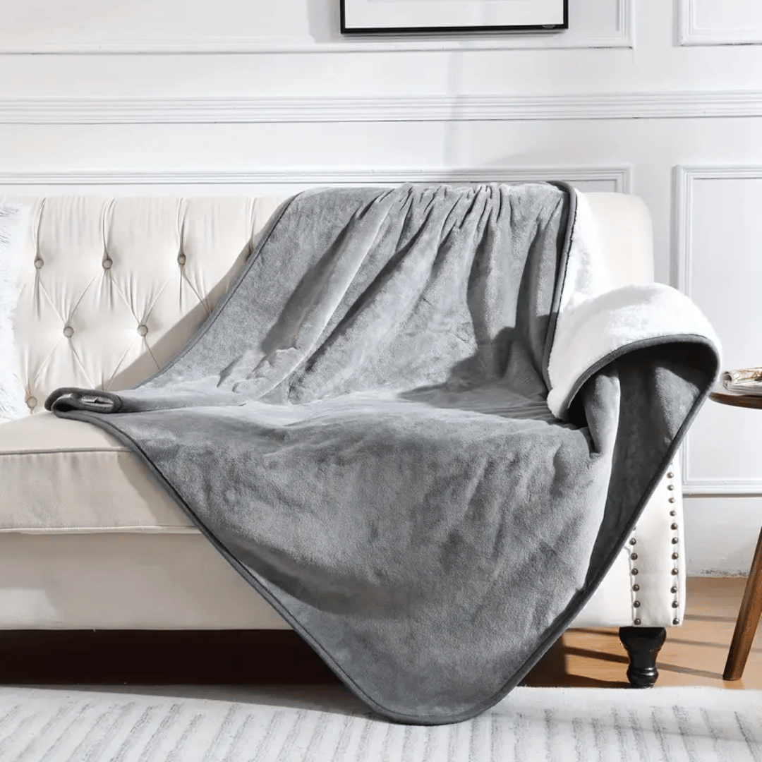 Gray blanket draped over a white sofa in a living room setting.
