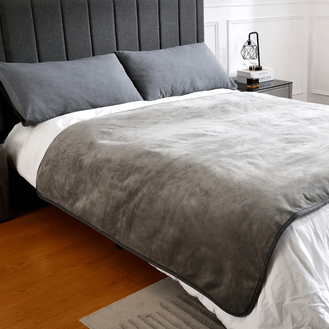 Gray comforter on a bed in a bedroom setting