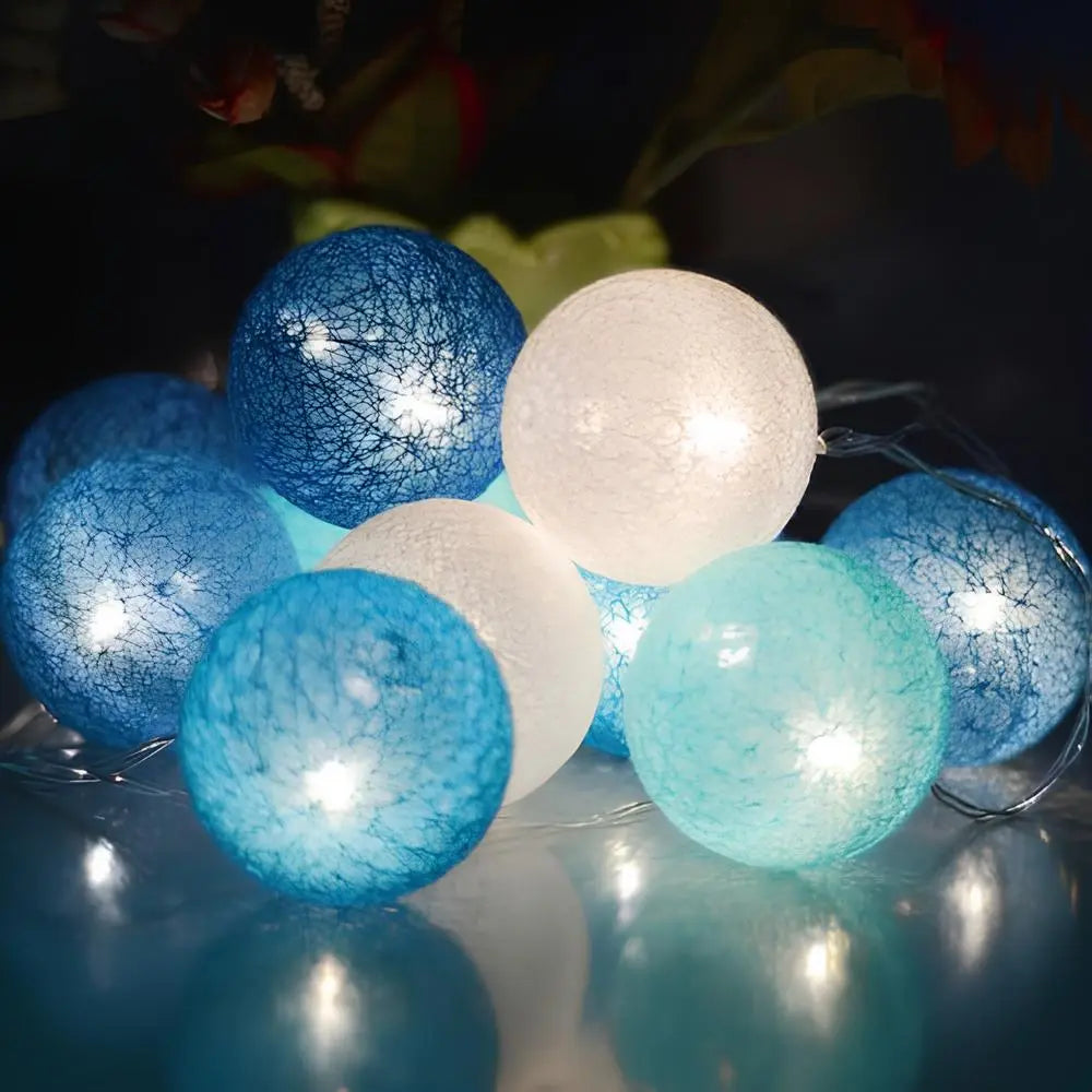 String of blue, white, and light blue spherical lights on a reflective surface.