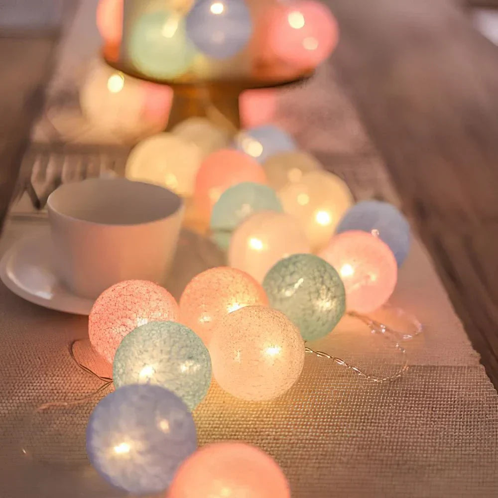String of colorful LED lights on a table with a cup and saucer in the background.