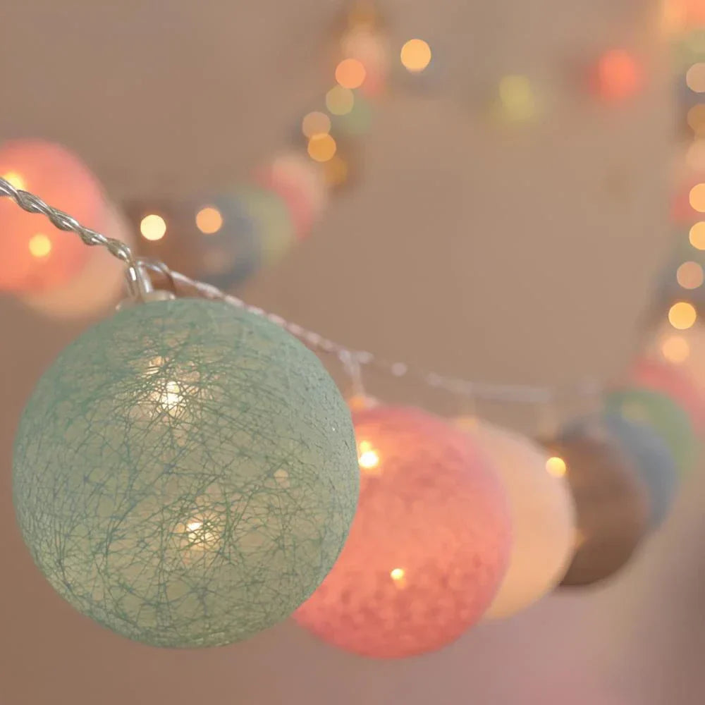 String of colorful cotton ball lights with a blurred bokeh background