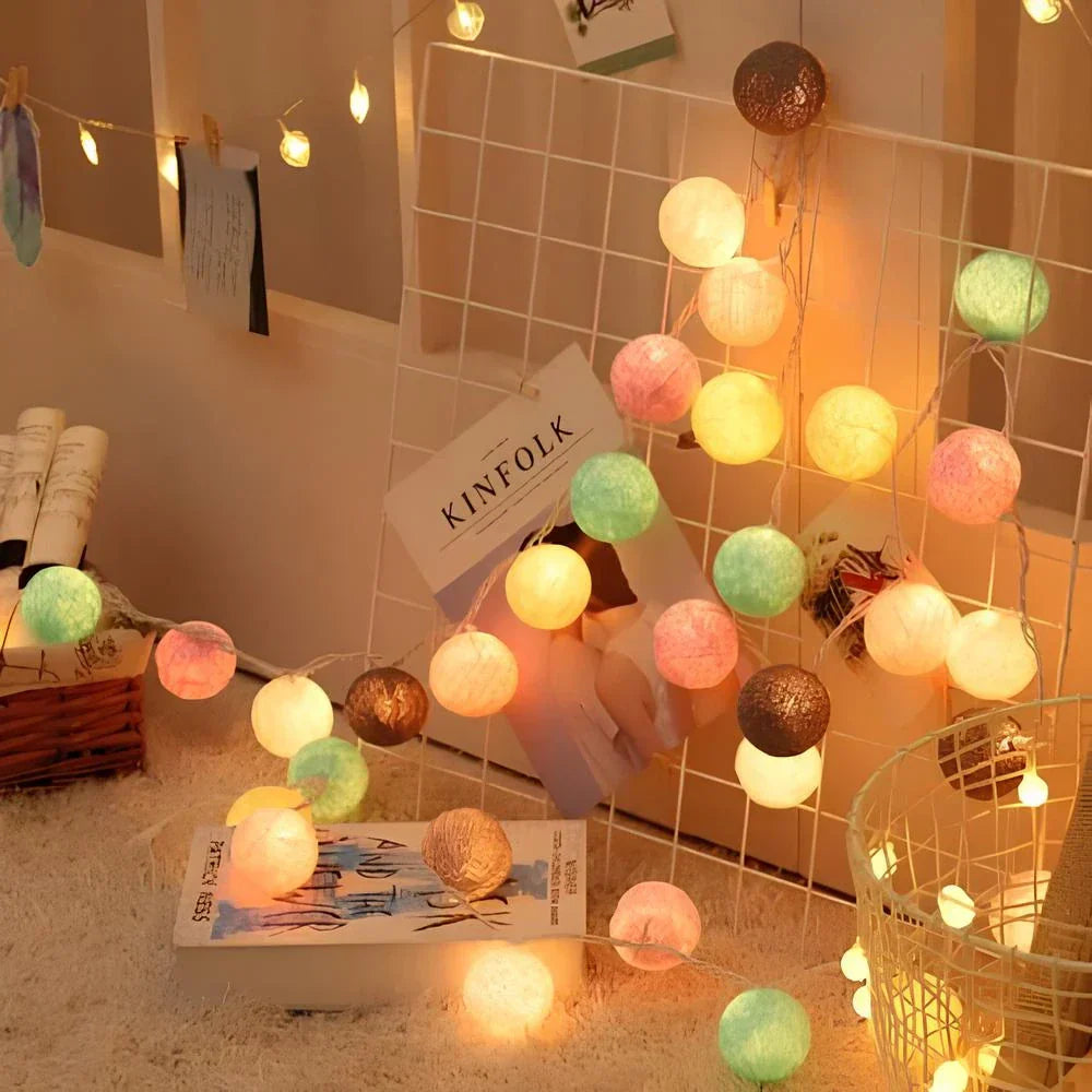 String lights with colorful bulbs on a decorative wall with 'KINFOLK' magazine.