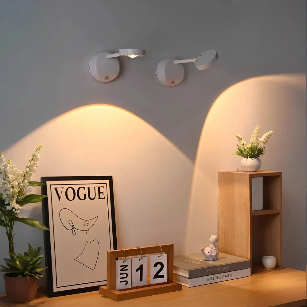 Decorative setup with wall lights, a 'Vogue' magazine, calendar, and small books on a shelf.
