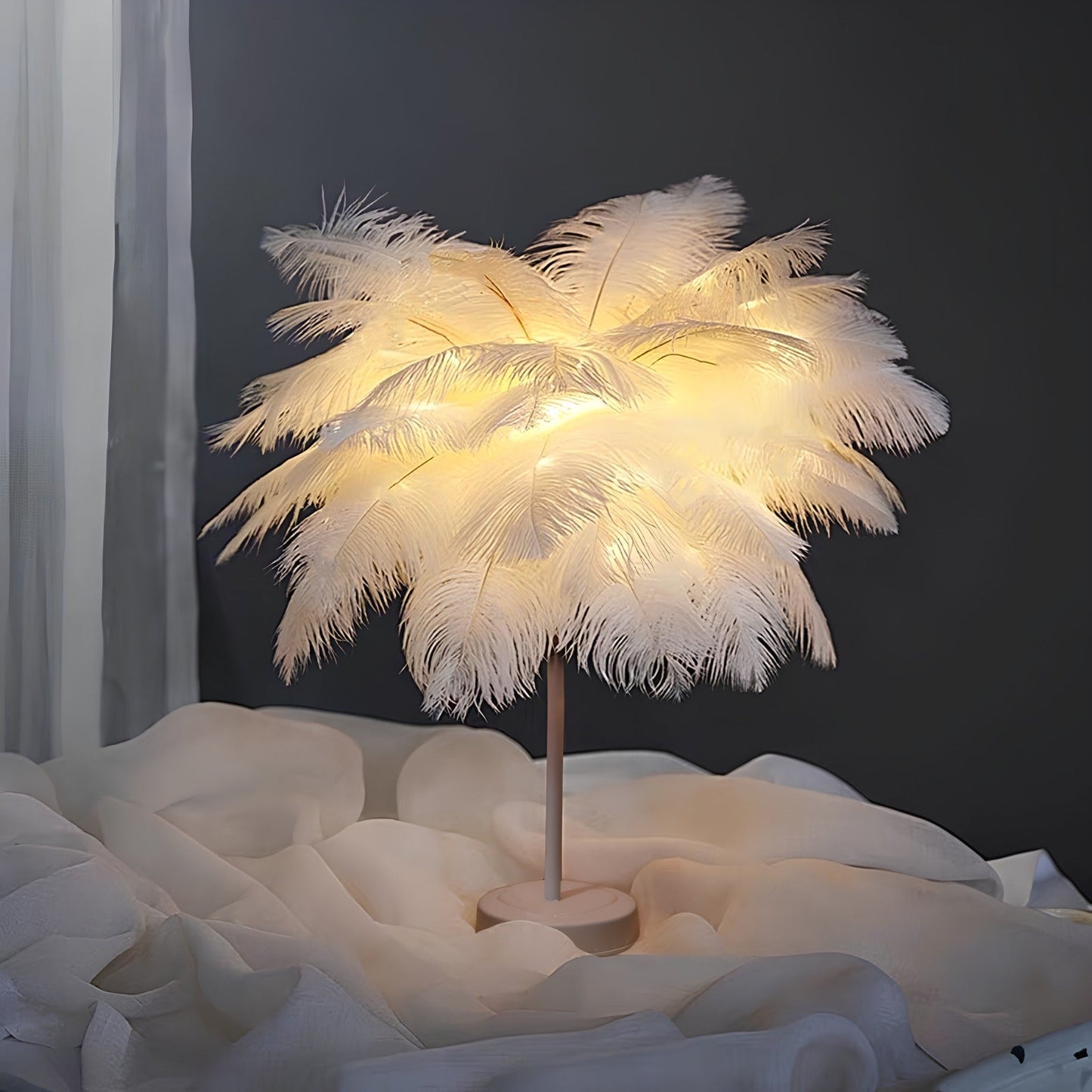 Feathered lamp with warm light on a soft white surface against a dark background