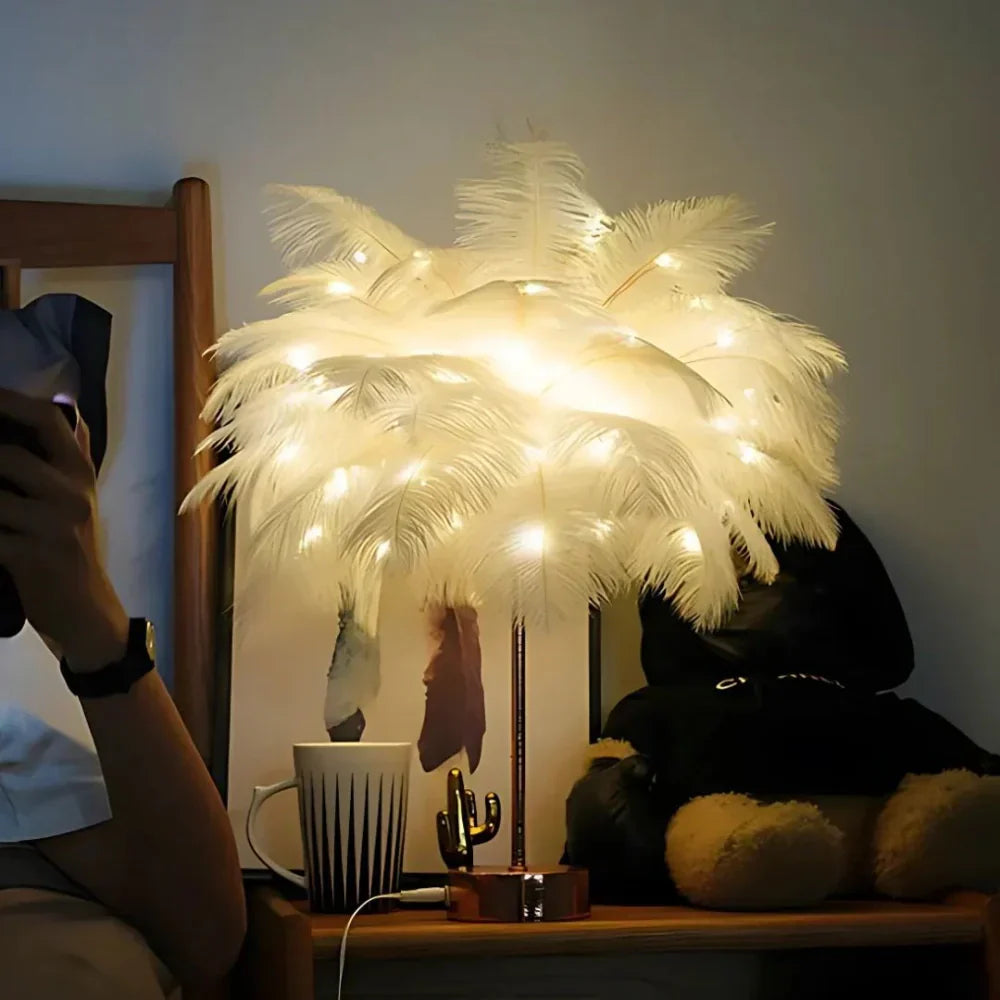 Decorative feather lamp with string lights on a table next to a mug and plush toy.