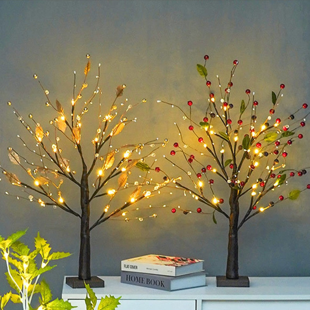 Decorative LED trees with lights on a shelf against a plain wall.