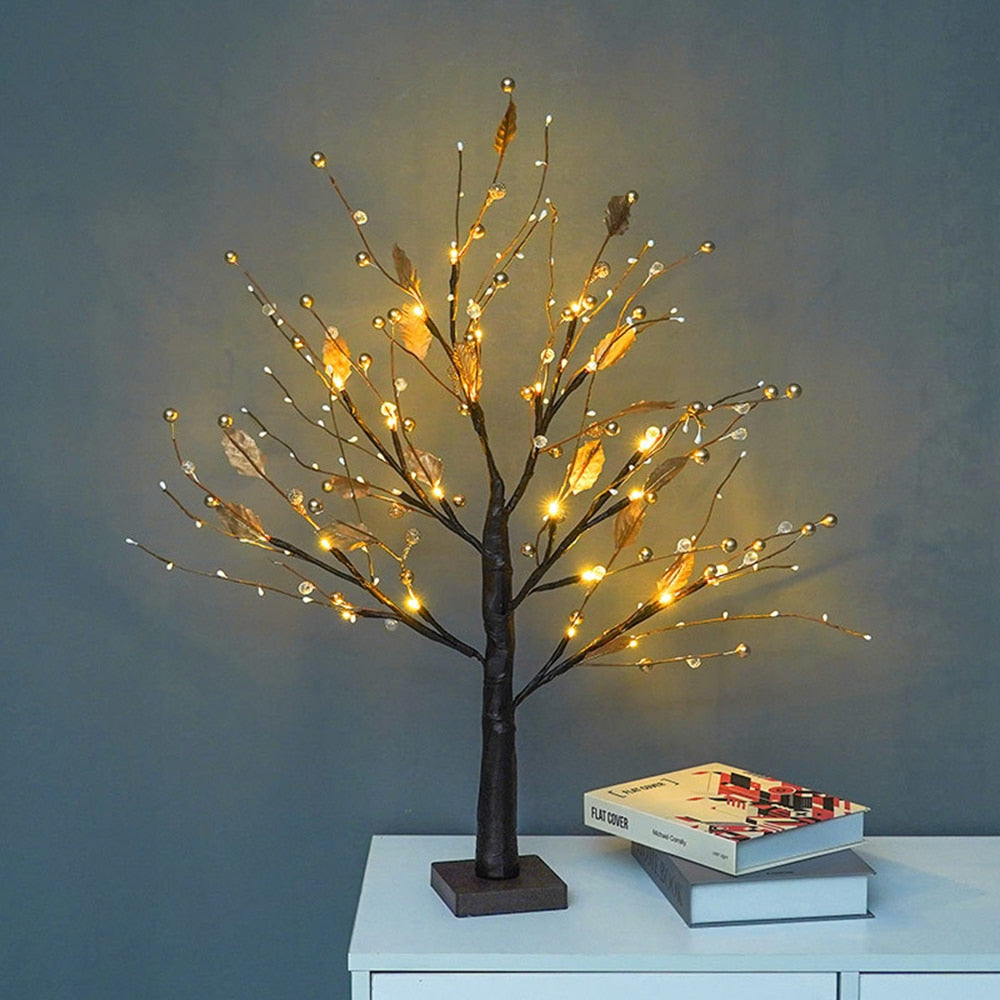 Decorative LED tree on a white surface with a gray background