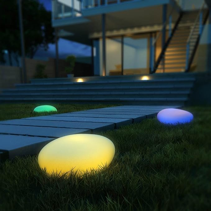 Colorful outdoor lights on grass near a modern house