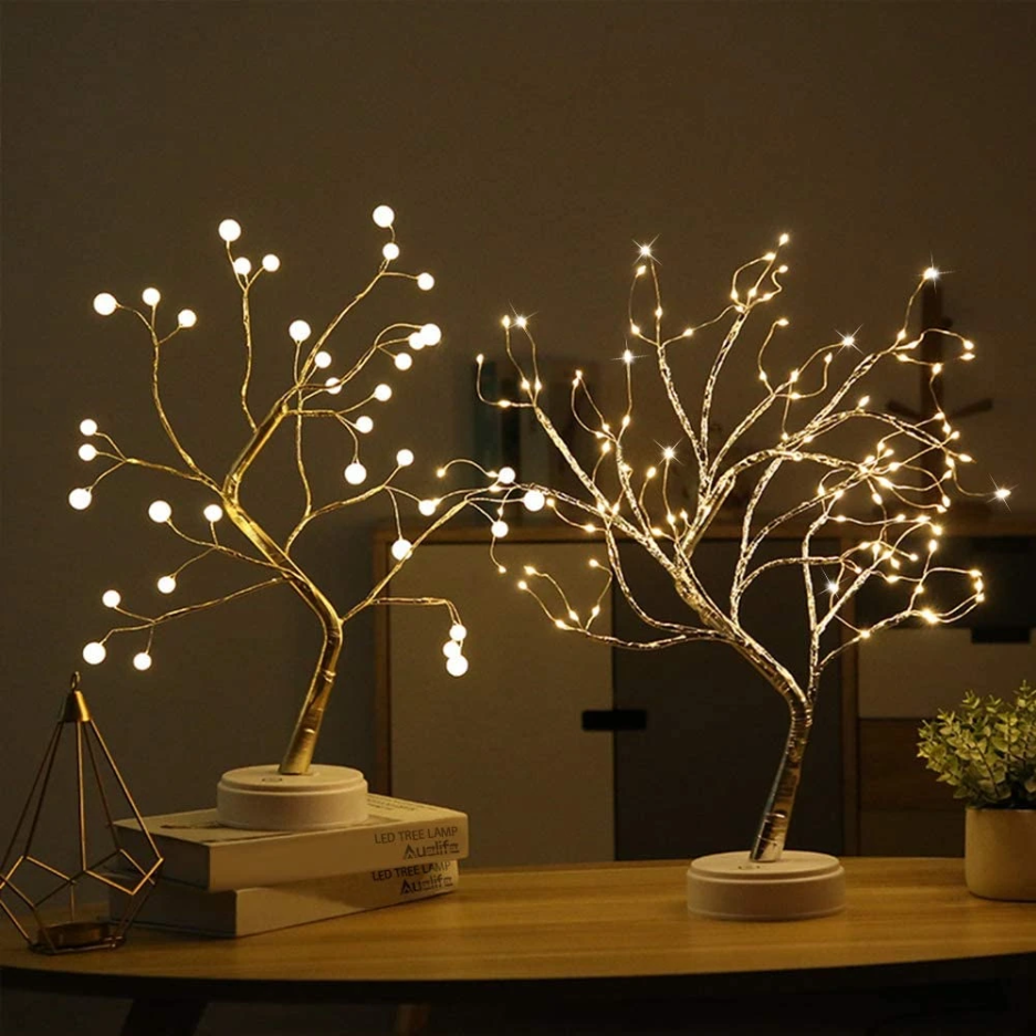 Two LED tree lights on a table with a dark background