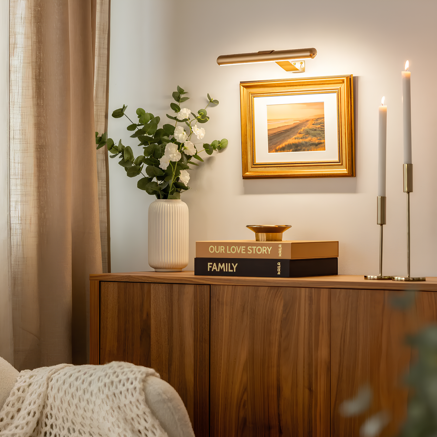 Wooden sideboard with decorative items including a vase, books, and a framed picture in a room setting.