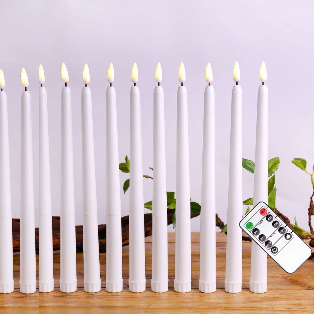 Row of white LED candles with remote control on a wooden surface