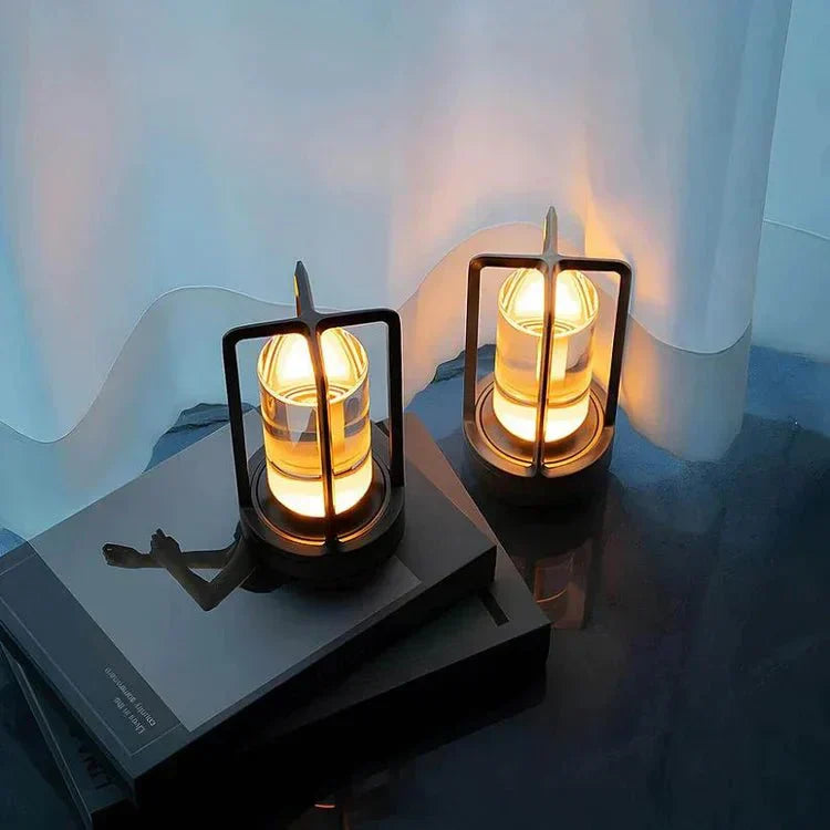 Two illuminated candle holders on a reflective surface with a blurred background