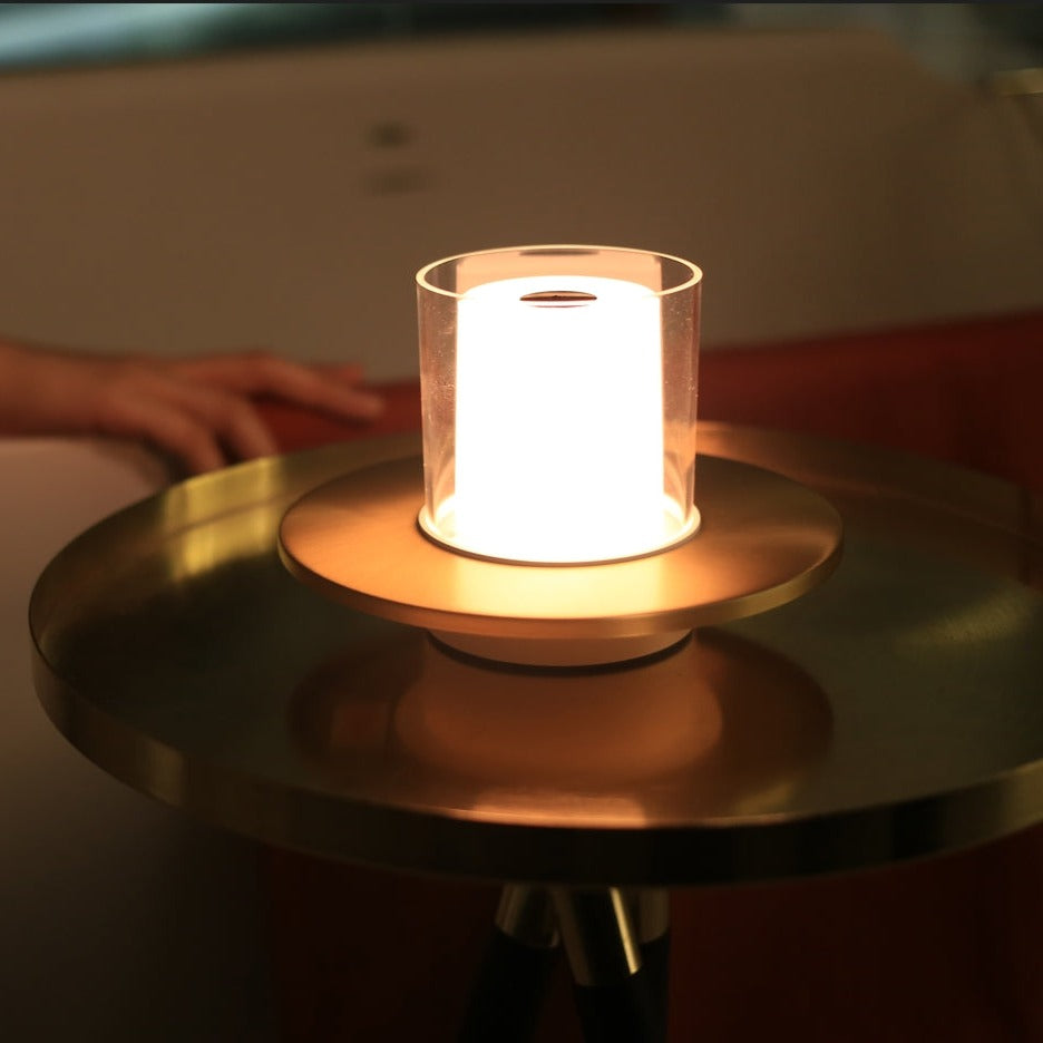 Small illuminated lamp on a reflective surface with a blurred background