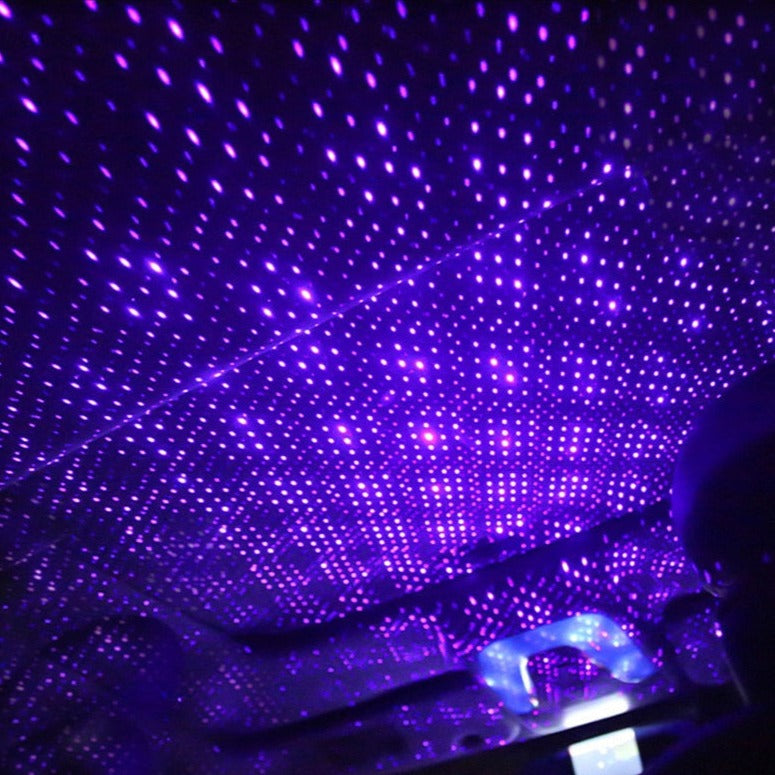 Car interior with starlight effect, illuminated by purple LED lights.