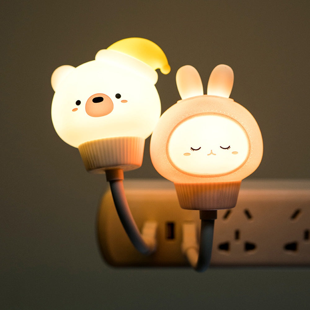 Two cartoon-style night lights, one bear and one rabbit, plugged into a wall socket.