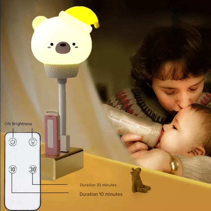Woman feeding a baby with a bottle next to a bear-shaped night light on a table.