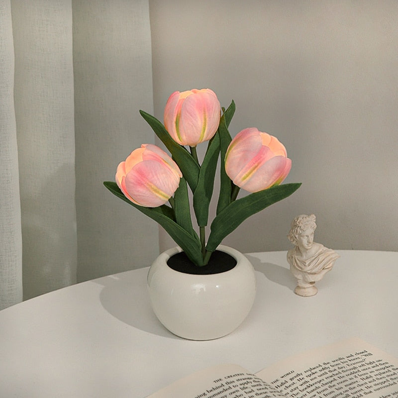 Pink tulips in a white vase on a table with a gray curtain background