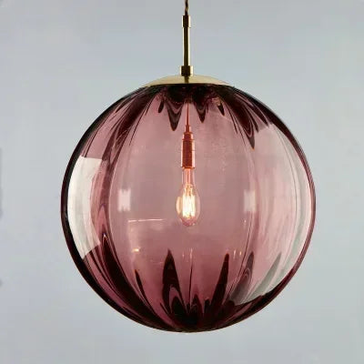 Purple glass pendant light with a visible bulb against a light gray background