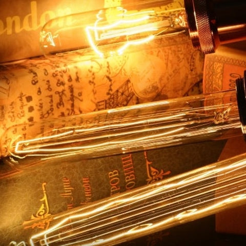 Close-up of a glowing light bulb inside an open book with Arabic text.