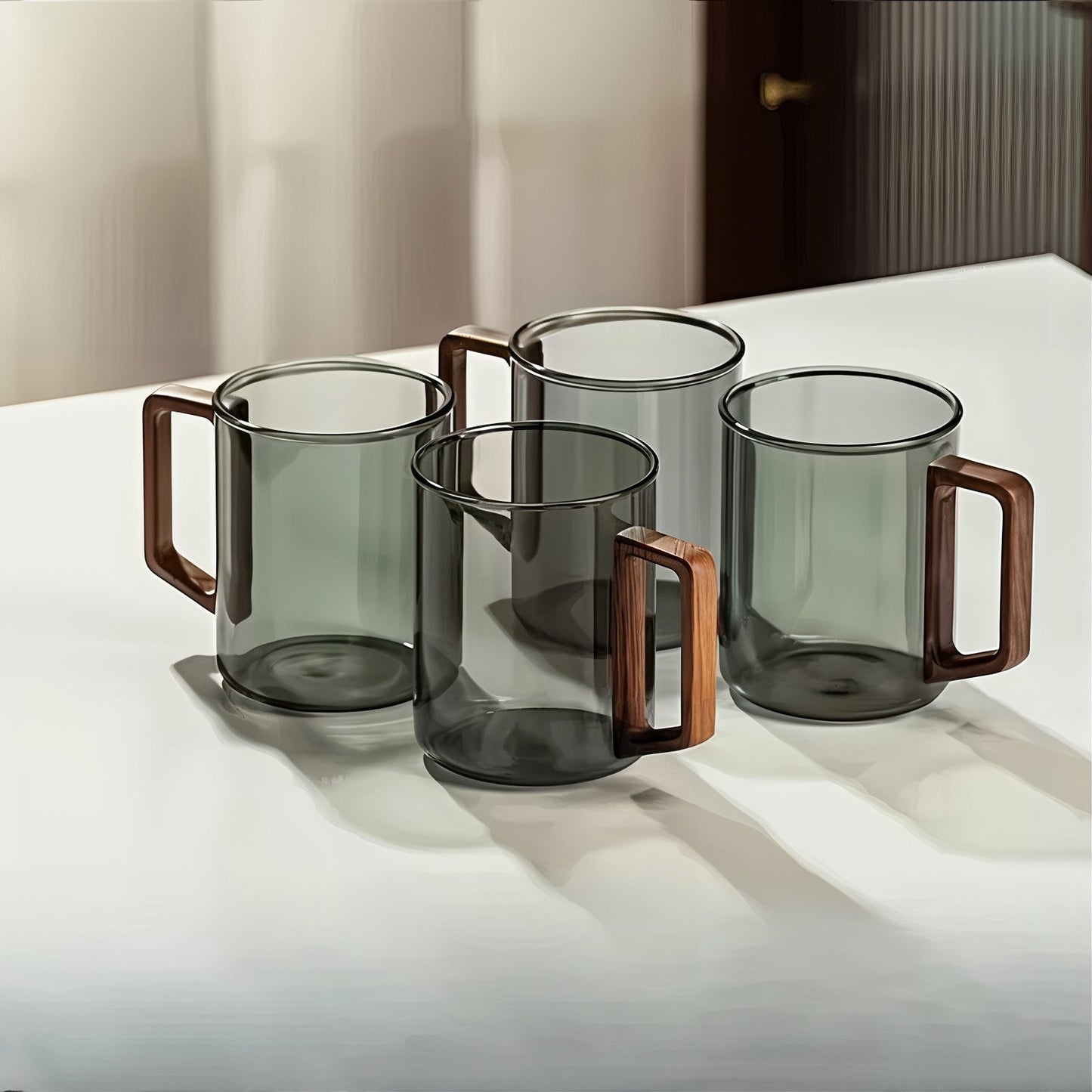 Set of four glass mugs with wooden handles on a white surface.