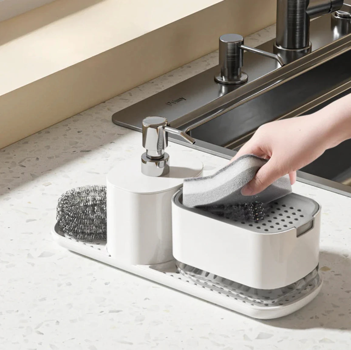 Kitchen sink caddy with scrubber and soap dispenser next to a faucet.
