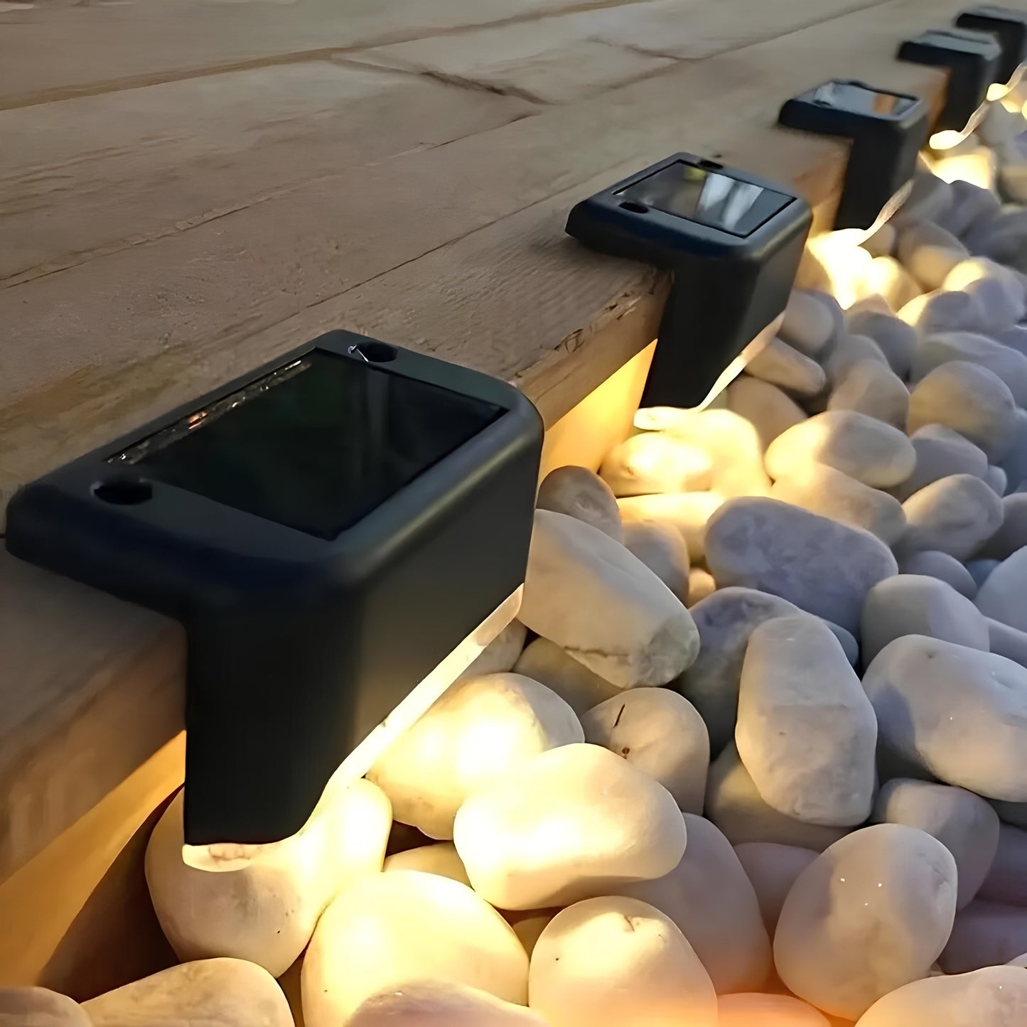 Black solar lights embedded in pebbles on a wooden surface