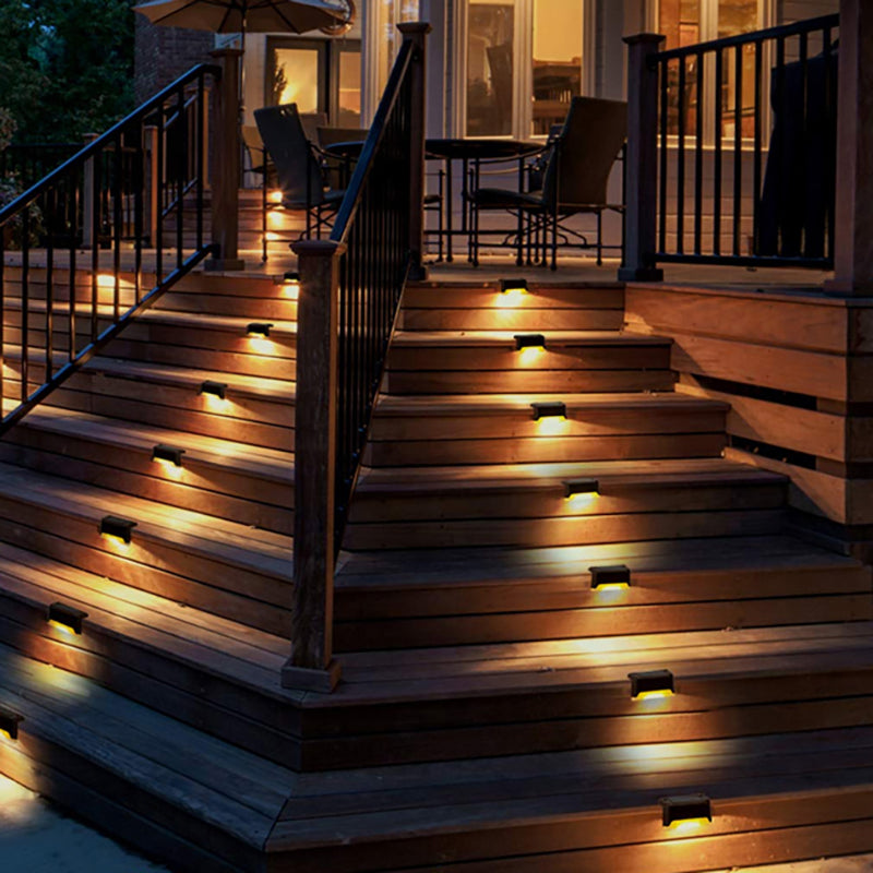 Wooden deck with illuminated steps and railing at night