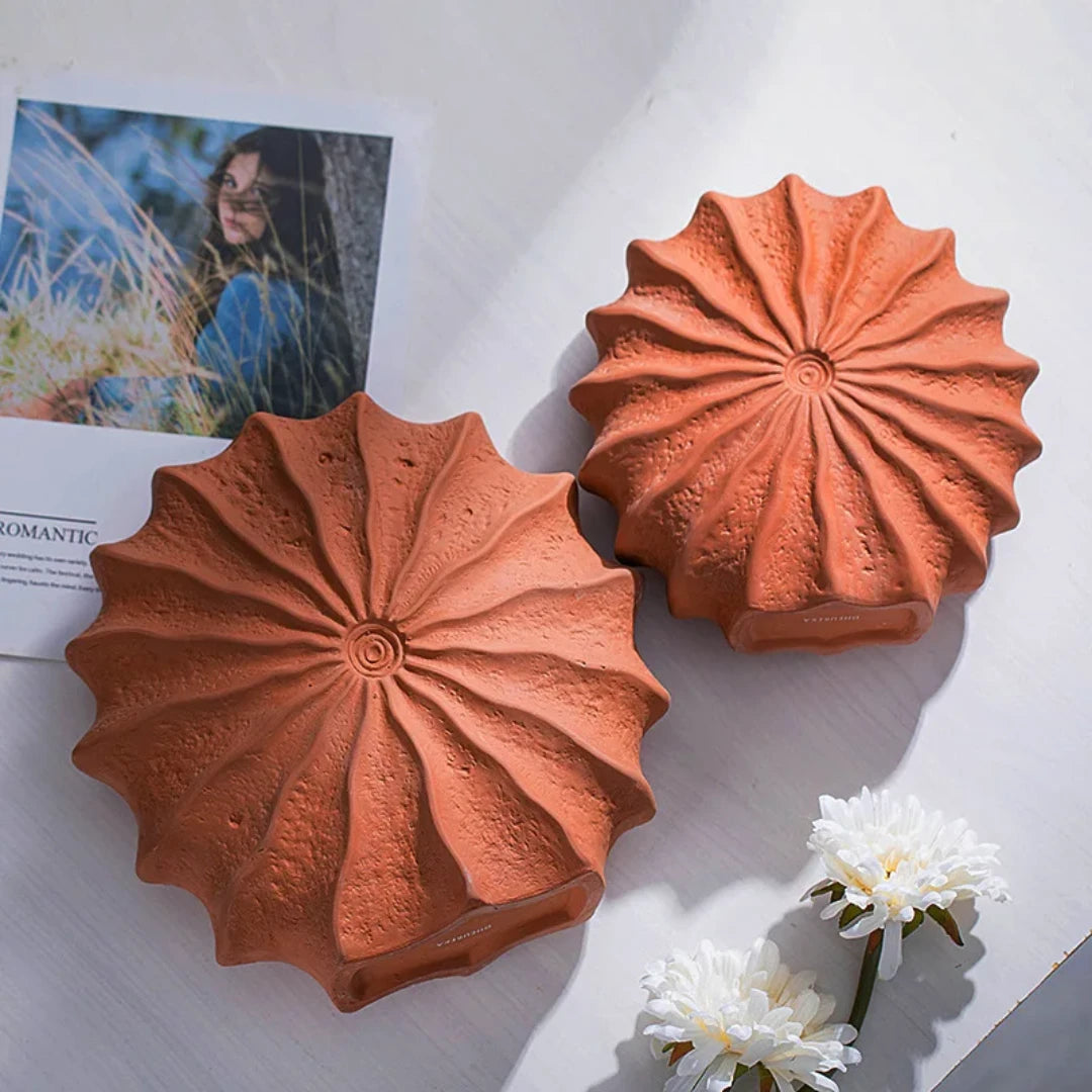 Josh & Tate - Terracotta Flower Vase - Two terracotta pots with decorative patterns on a light surface with flowers and a magazine.