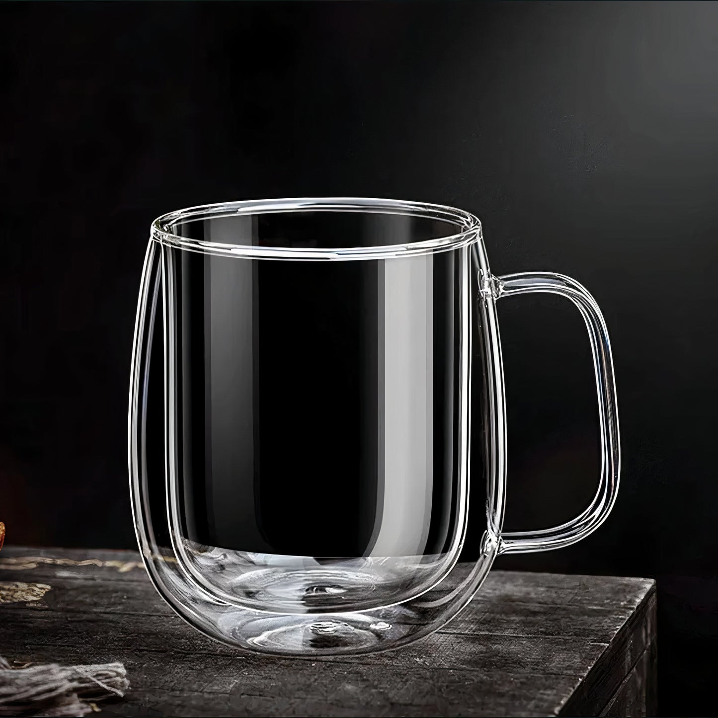 Clear glass mug with handle on a dark surface and background