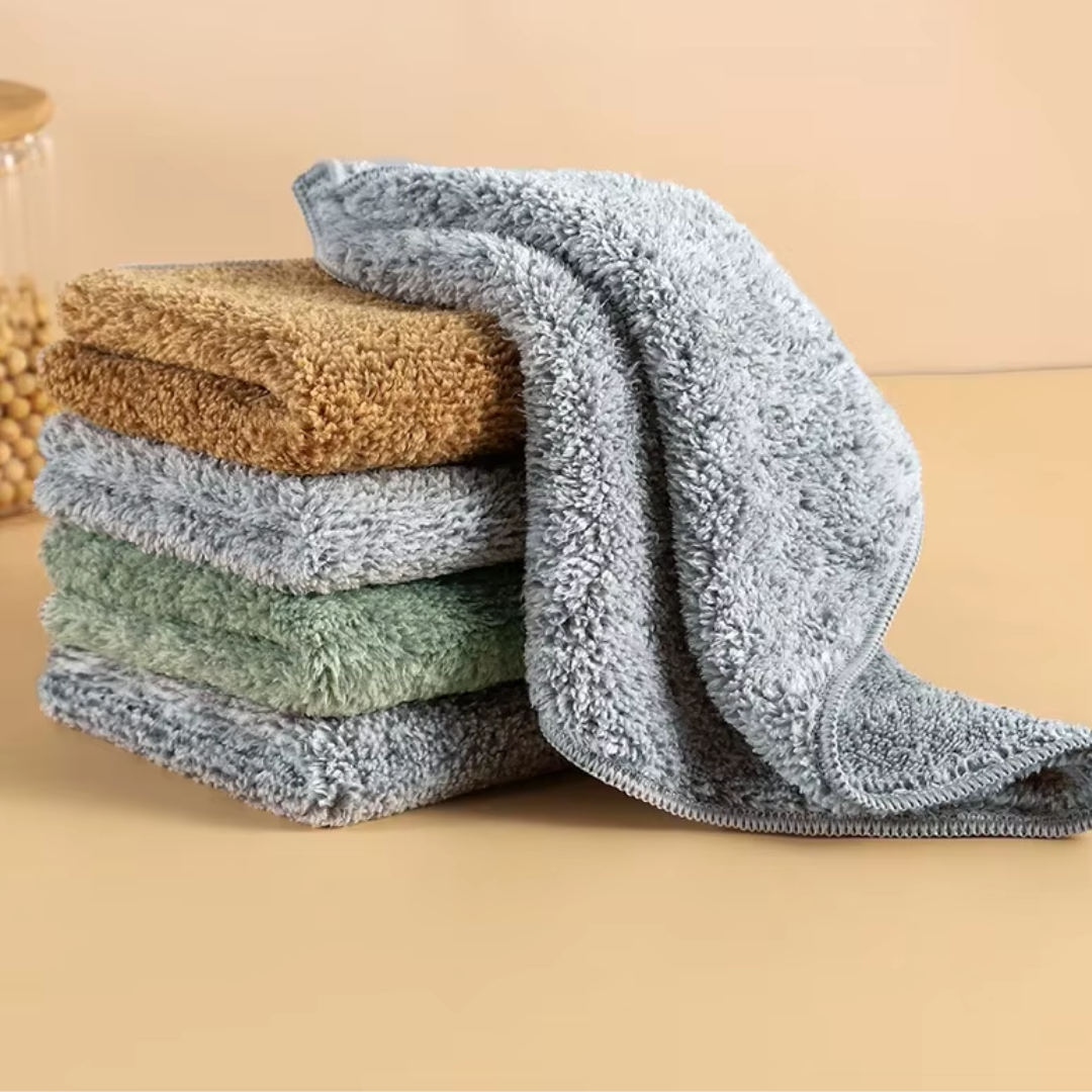 A stack of three TidyMax™ Towels in beige, green, and gray, displayed on a neutral background.