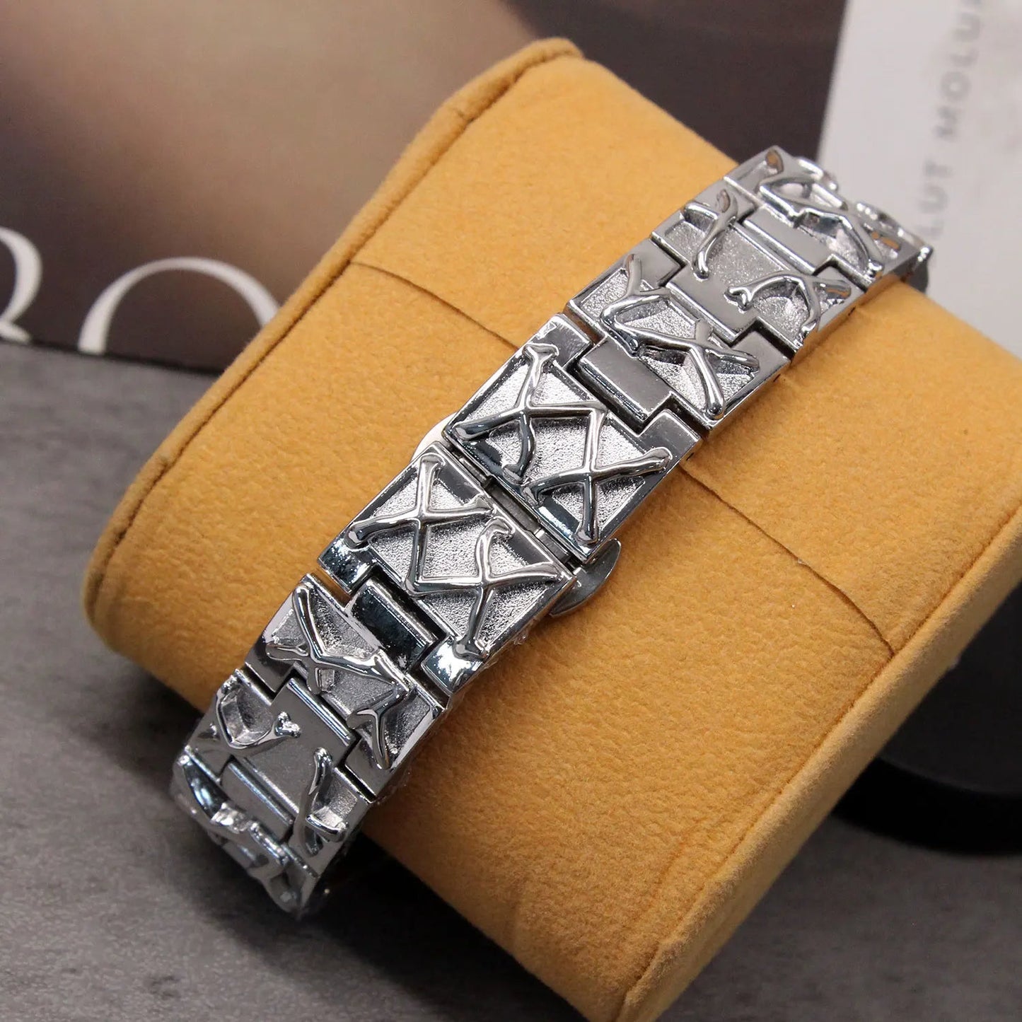 Silver bracelet on a yellow cushion with a blurred background