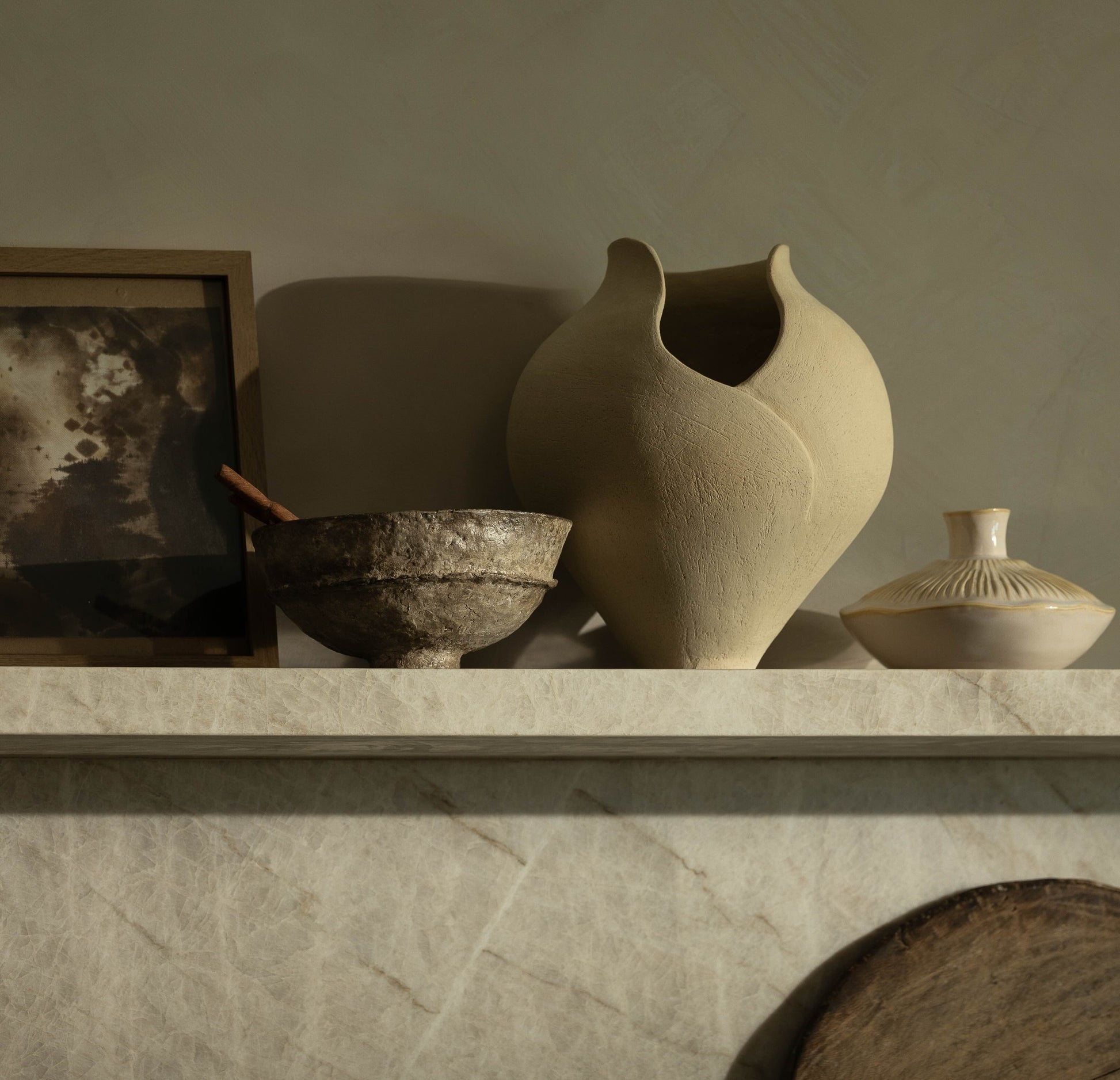 Decorative shelf with ceramic vases and bowls against a neutral wall.