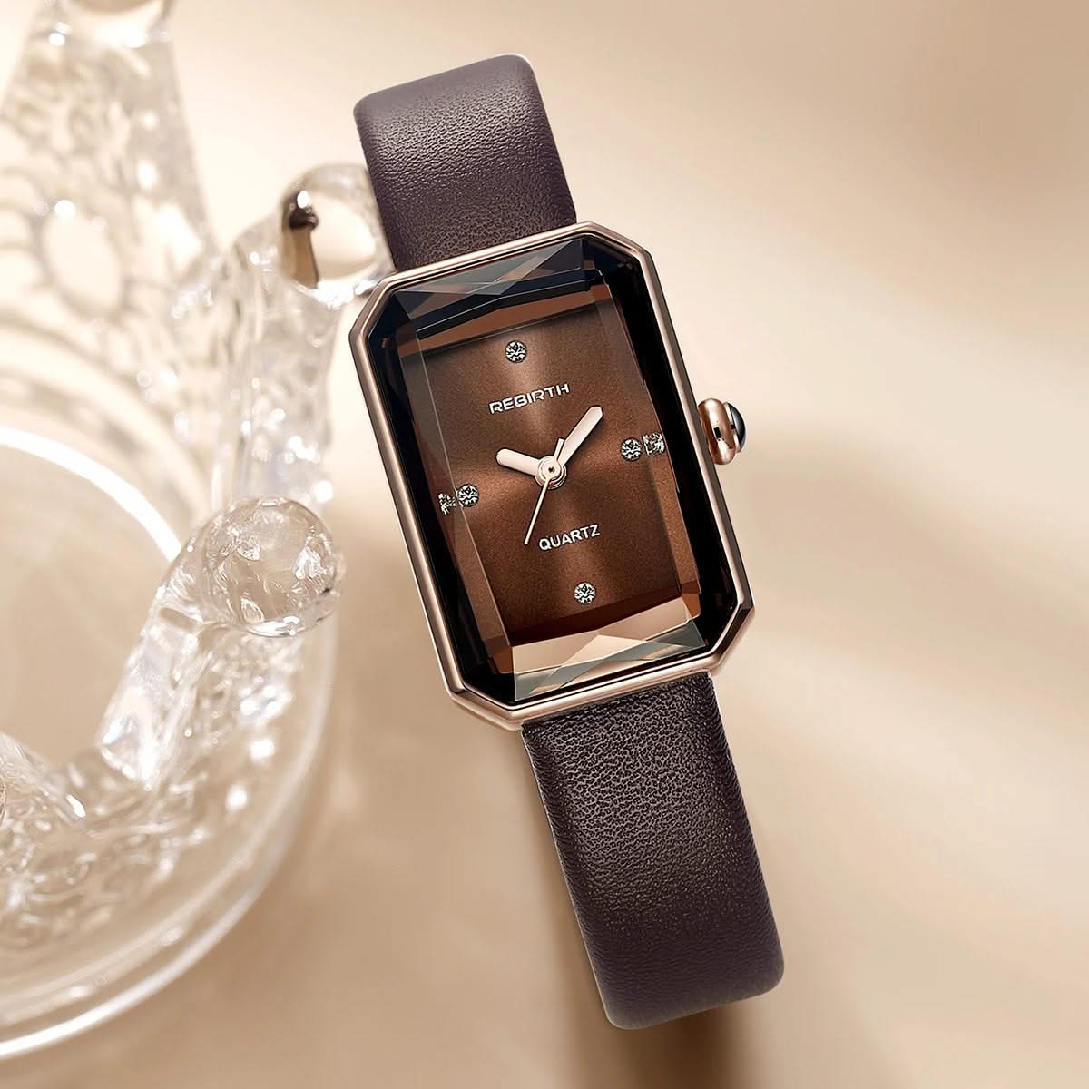 Brown watch with a textured strap on a beige background
